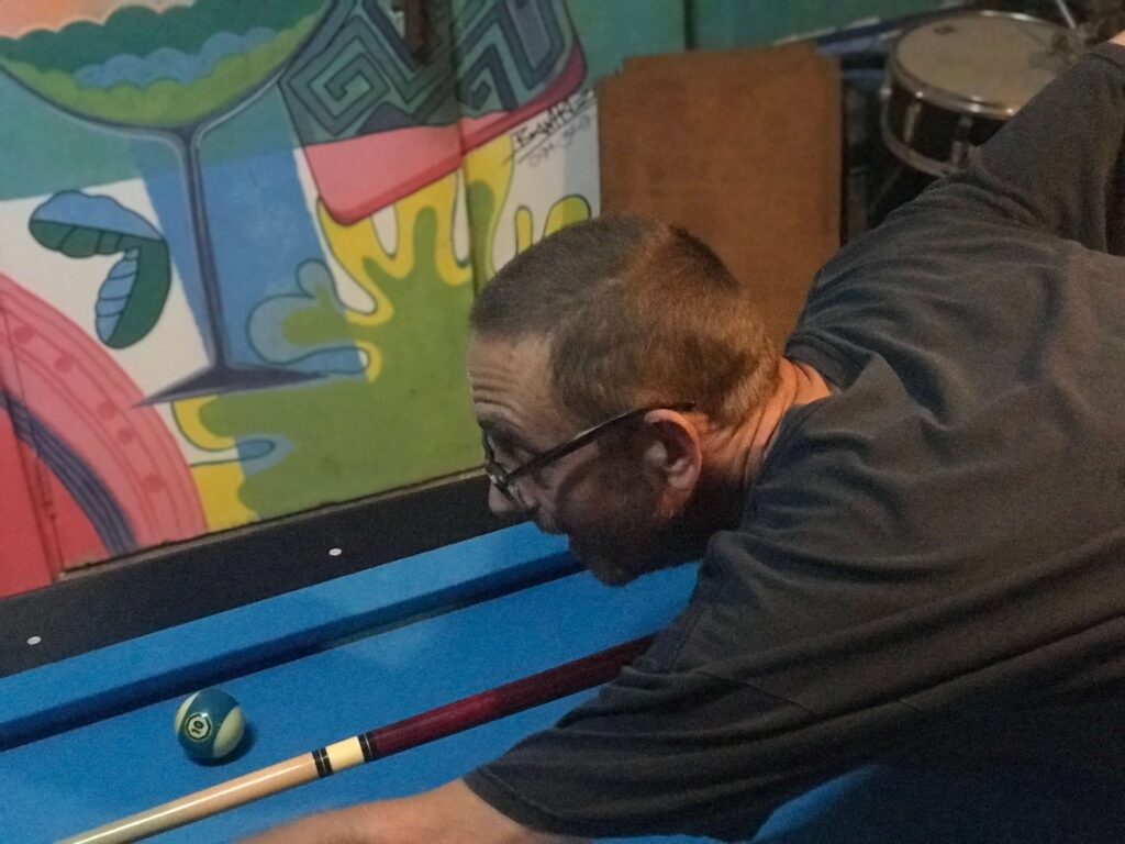 A photo of the owner, Mike, playing pool / billiard in Chiang Rai on the new pool table.